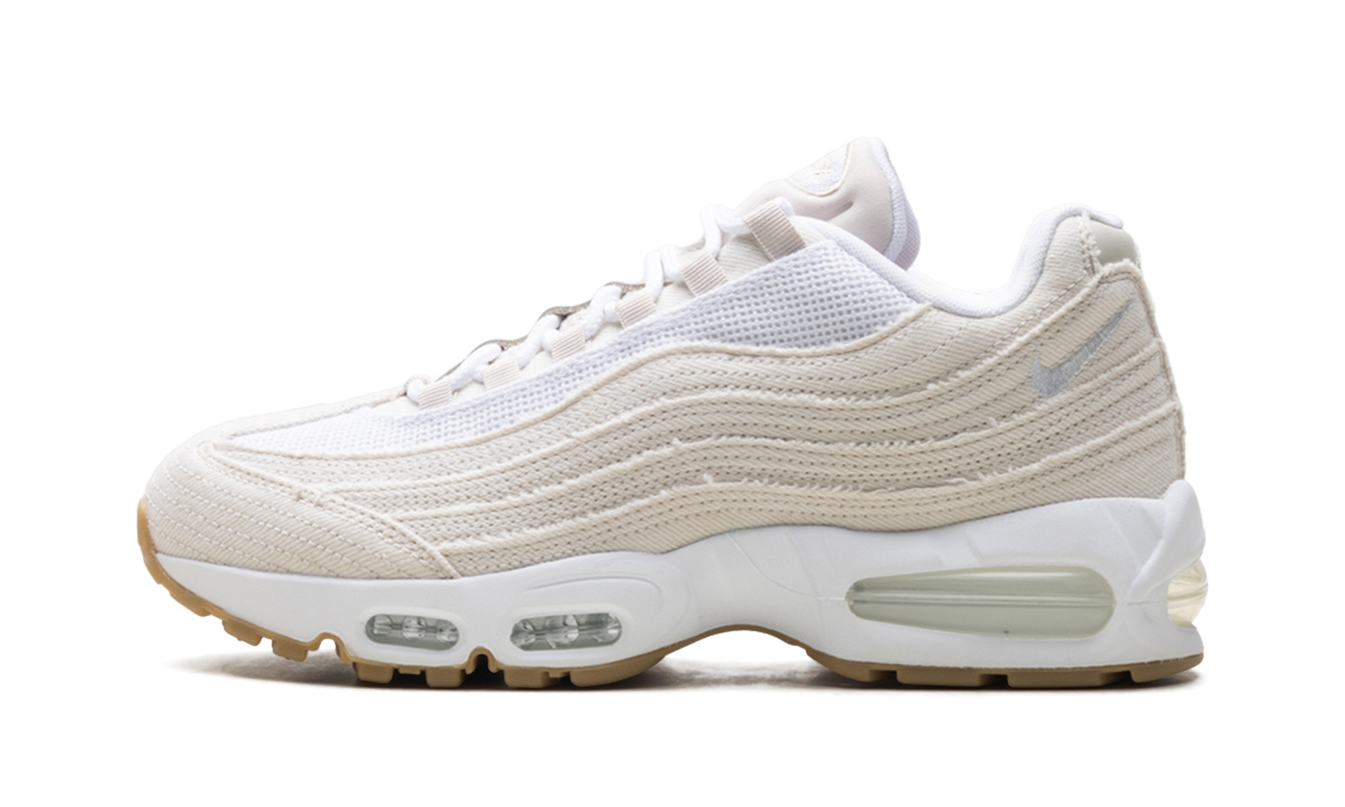 Lichte Orewood Brown Nike Air Max 95 OG schoenen met Levi's denim details, getoond in close-up op een witte achtergrond.