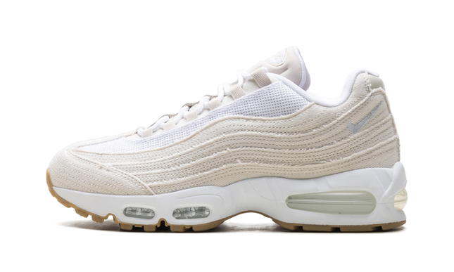 Lichte Orewood Brown Nike Air Max 95 OG schoenen met Levi's denim details, getoond in close-up op een witte achtergrond.