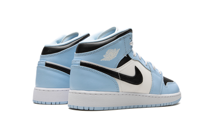 Lichte blauwe Air Jordan 1 Mid GS schoenen met witte details en zwart logo, zichtbaar van de zijkant.