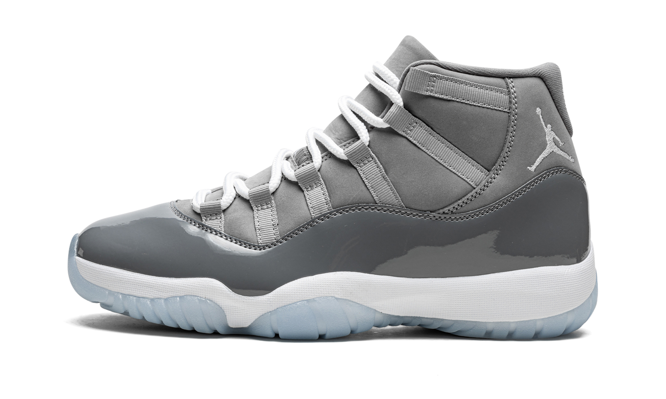 Zwarte en grijze Air Jordan 11 Retro schoenen met glanzende afwerking en witte zool, ontworpen voor stijl en comfort.