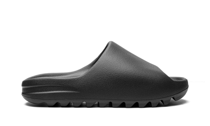 Zwarte Yeezy Slide "Onyx 2022/2023" sneakers met comfortabele voetbed en minimalistisch design, gedragen door een model.