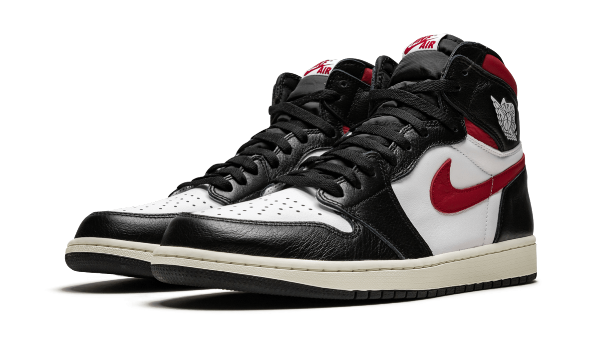 Zwarte en rode Air Jordan 1 Retro High OG sneakers met witte details en leren afwerking, zichtbaar in close-up.