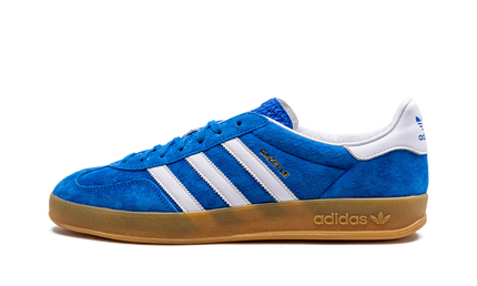 Blauwe Adidas Gazelle Indoor schoenen met witte details en zwarte zool, geschikt voor binnen sporten.