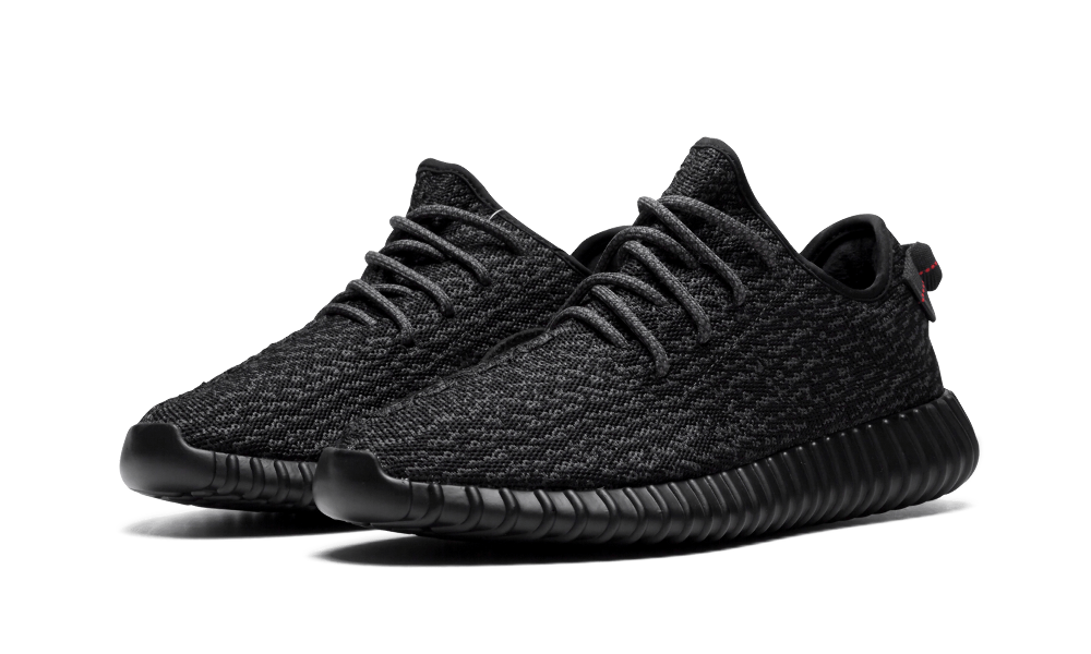 Zwarte Adidas Yeezy Boost 350 sneakers met pirate-achtige details, zichtbaar op een witte achtergrond.