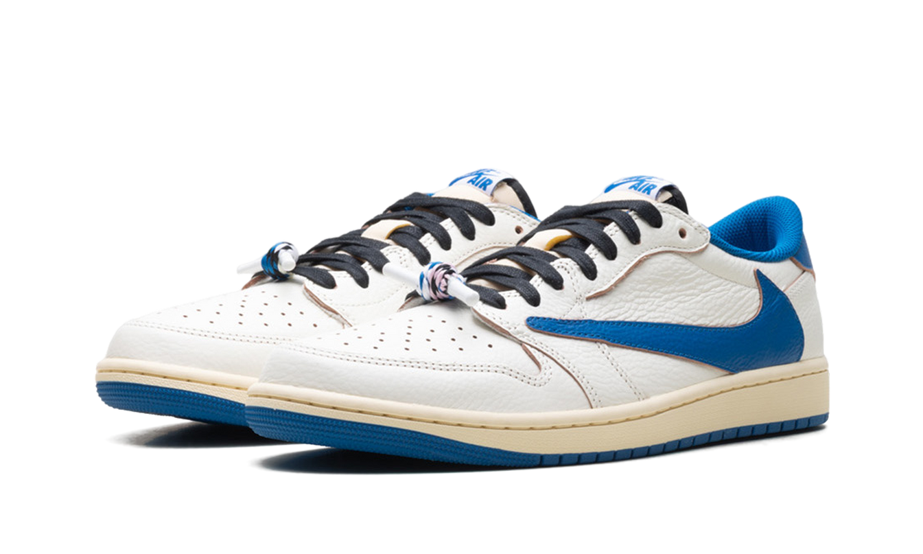 Lichte zandkleurige Air Jordan 1 Low Travis Scott Fragment sneakers met witte details en zwart accenten, gelegen op een witte ondergrond.