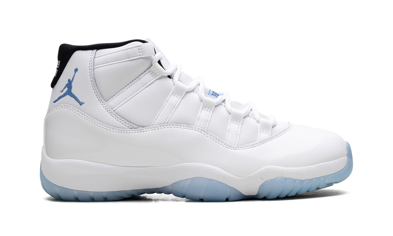 Witte en blauwe Air Jordan 11 Retro sneakers met glanzende afwerking en Nike Swoosh, gedragen door een model.