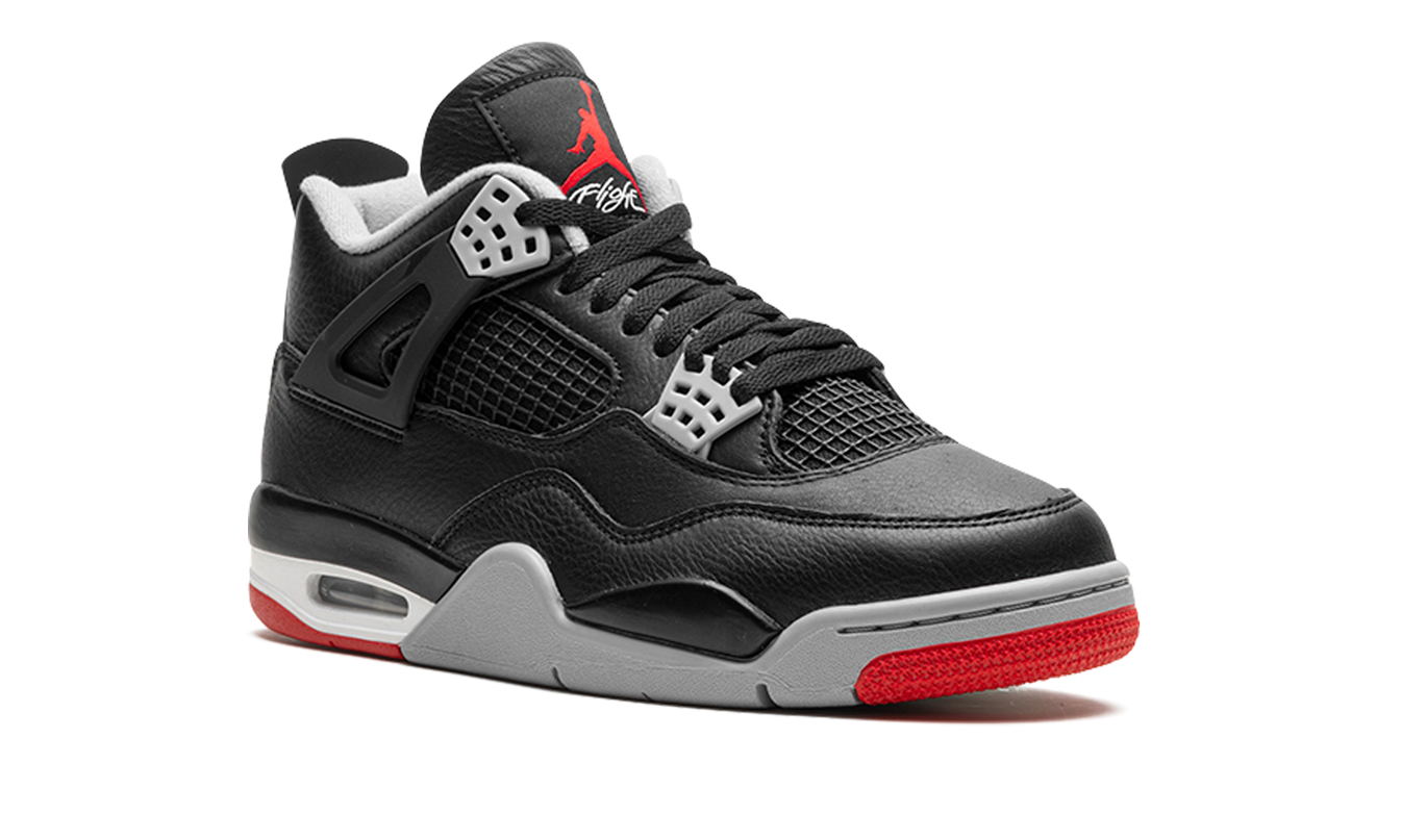 Zwarte Air Jordan 4 sneakers "Bred Reimagined" met rood details en witte zool, zichtbaar van de zijkant.