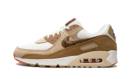 Nike Air Max 90 damesschoenen met licht ivoor kleur en slangenhuid détail, Swoosh-logo zichtbaar op de zijwand.