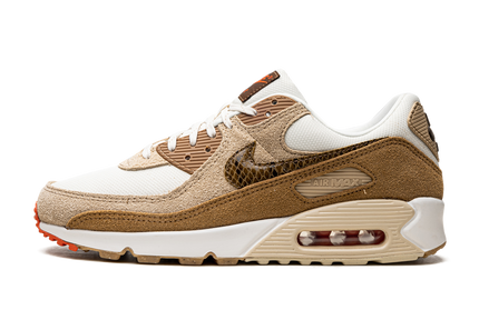 Nike Air Max 90 damesschoenen met licht ivoor kleur en slangenhuid détail, Swoosh-logo zichtbaar op de zijwand.