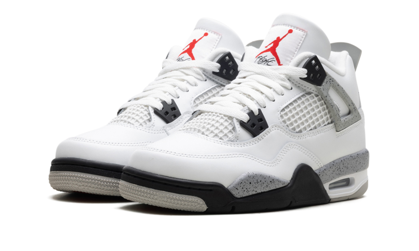 Witte Air Jordan 4 Retro GS sneakers met cementprint details en zwarte accenten, gelegen op een witte achtergrond.