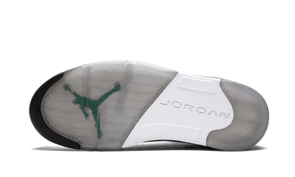 Zwarte en paarse Air Jordan 5 Retro sneakers met witte details en doorzichtige zool op een witte achtergrond