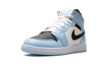 Lichte blauwe Air Jordan 1 Mid GS sneakers met witte accenten en blauwe details, zichtbaar van de zijkant.