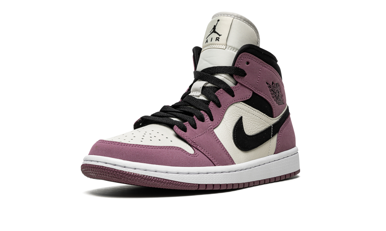Lichte roze en witte Air Jordan 1 MID SE schoenen voor dames, zichtbaar vanuit een zijaanzicht.