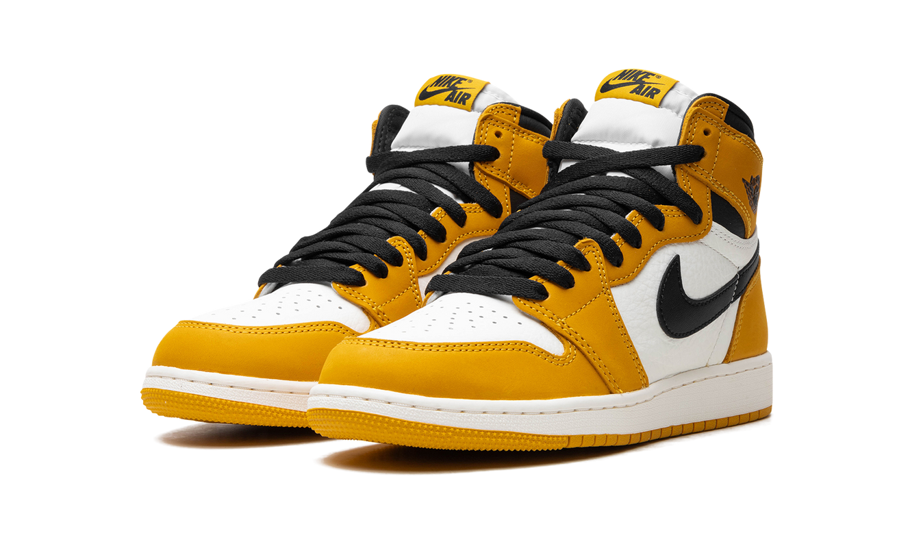 Zwarte en gele Air Jordan 1 Retro High OG GS sneakers met gele ochre details en witte zool, zichtbaar op de afbeelding.