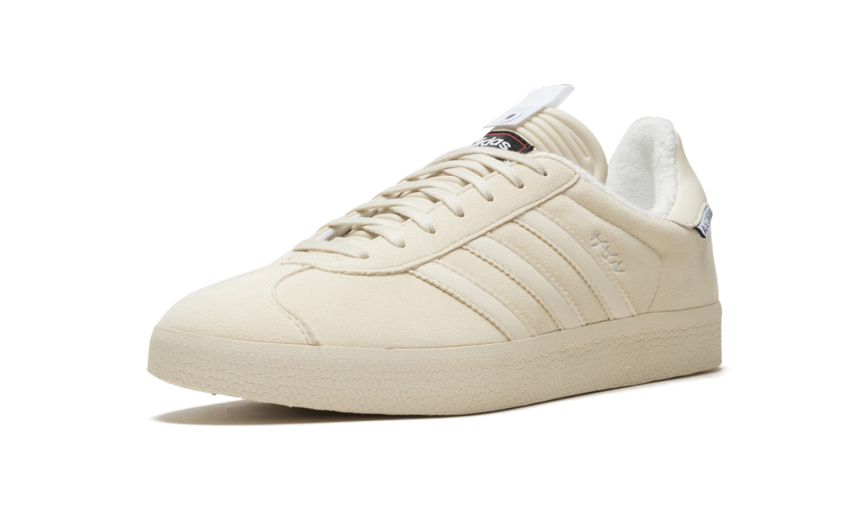 Lichte Adidas Gazelle SE 'UA&SONS' sneakers in wit en groen, zichtbaar met stoffen veters en merklogo aan de zijkant.