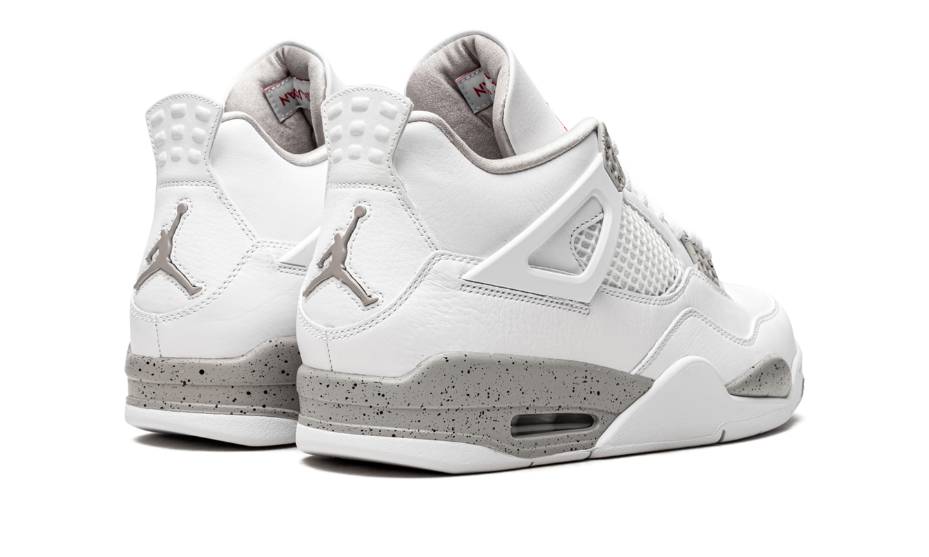 Witte Air Jordan 4 Retro sneakers met zwart en grijze details, lage schacht en leren bovenwerk.