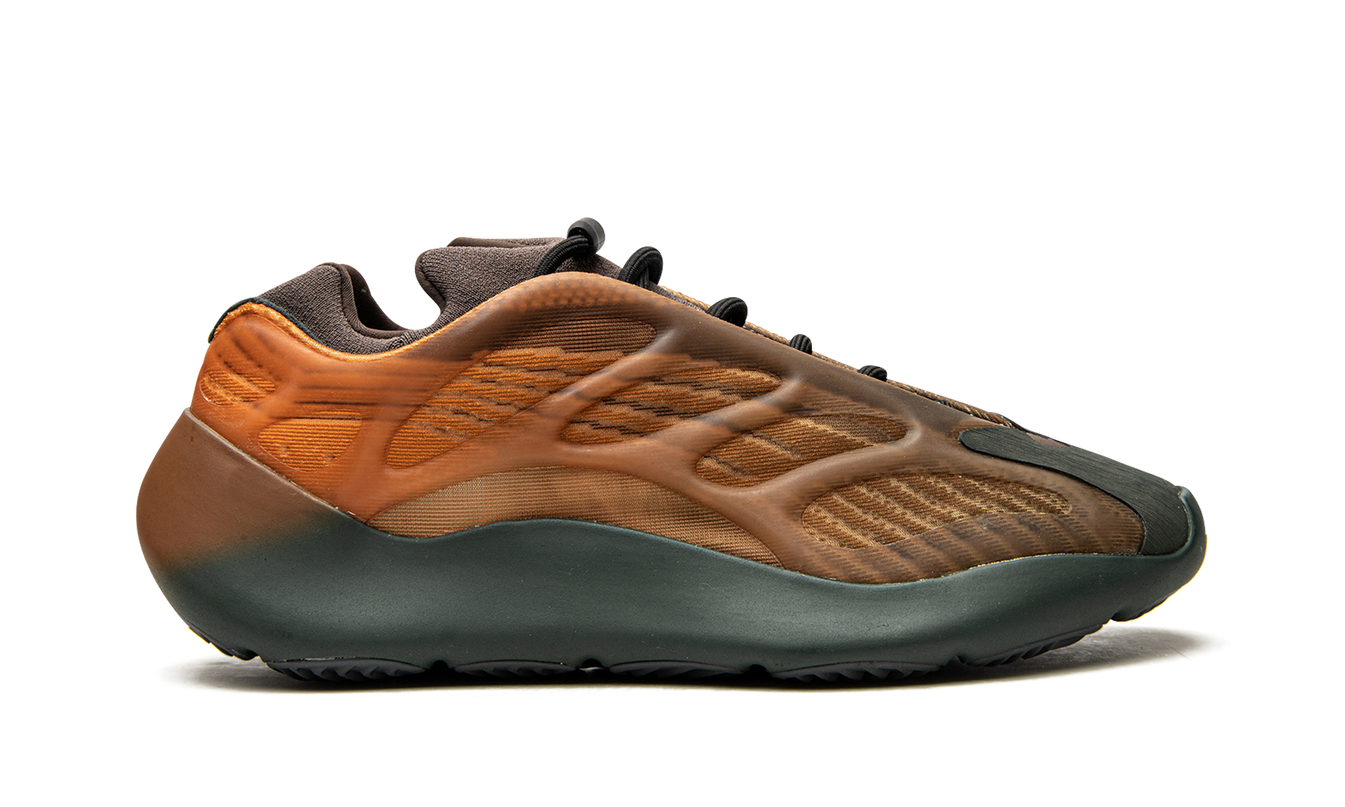 Bruine Yeezy 700 V3 "Copper Fade" sneakers met futuristisch ontwerp en opvallende details, gedragen door een model.