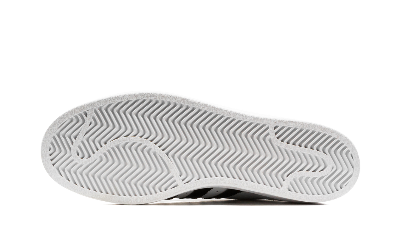 Witte en zwarte Superstar schoenen van Mijn winkel, close-up van de sportieve sneakers met witte zool en zwart detail.