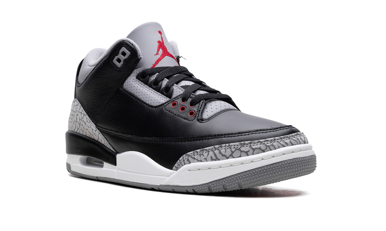 Zwarte Air Jordan 3 "Black Cement" sneakers met grijze details en witte zool, zichtbaar in close-up.