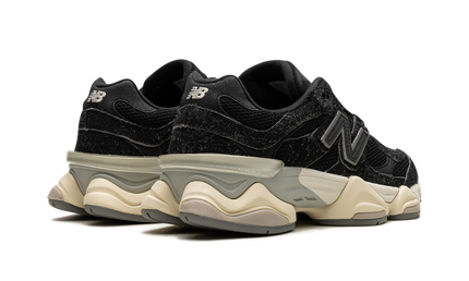 Zwarte New Balance 9060 schoenen met suède details, geschikt voor casual en sportieve outfits.