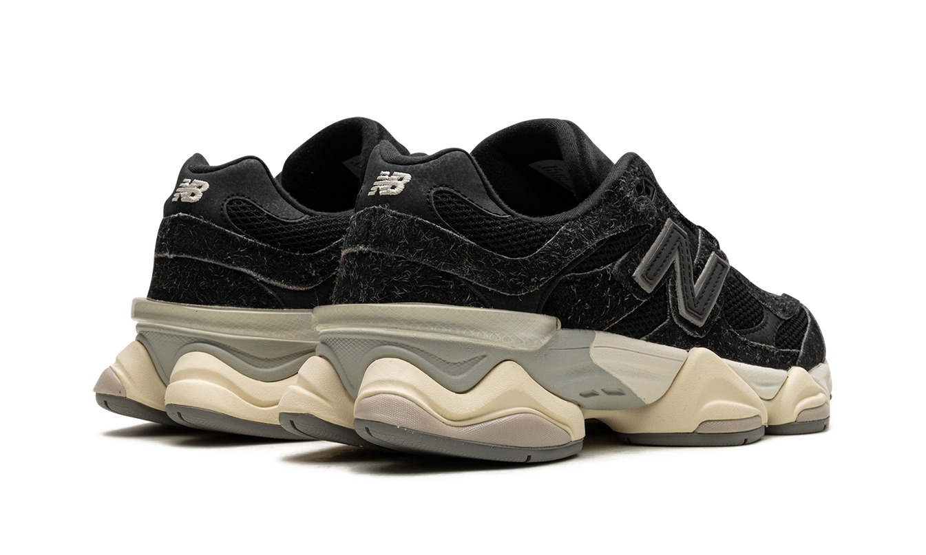 Zwarte New Balance 9060 schoenen met suède details, geschikt voor casual en sportieve outfits.