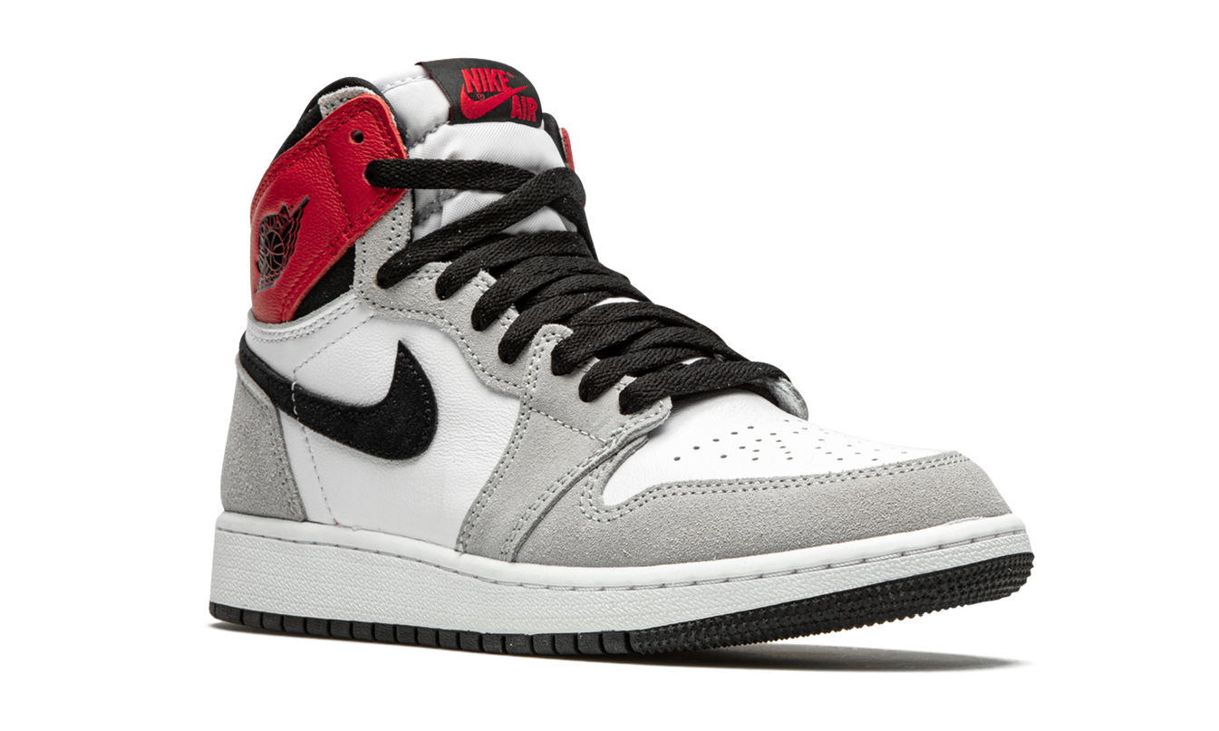 Lichte grijze Air Jordan 1 Retro High OG GS schoenen met witte accenten en zwarte details, zichtbaar in close-up.