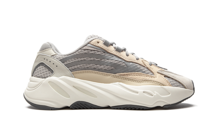 Witte Yeezy Boost 700 V2 sneakers met dikke zool en gestroomlijnd ontwerp, gedragen door een model op een witte achtergrond