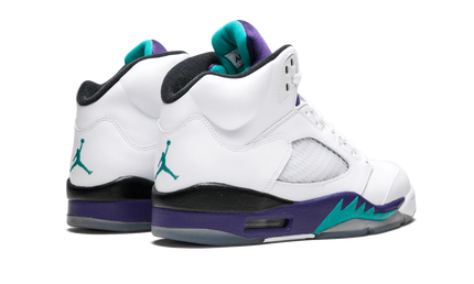 Witte en paarse Air Jordan 5 Retro sneakers met paarse accenten en doorzichtige zool op een neutrale achtergrond