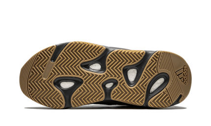 Zwarte Yeezy Boost 700 sneakers met dikke zool en zwarte bovenkant, gedragen door een model, gericht op comfort en stijl.