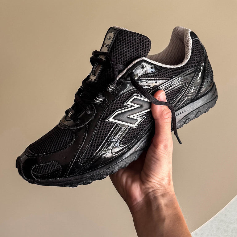 Zwarte New Balance 204L sneakers met Timberwolf details van CAPE EXCLUSIVES, close-up van de schoen met leren en mesh materialen