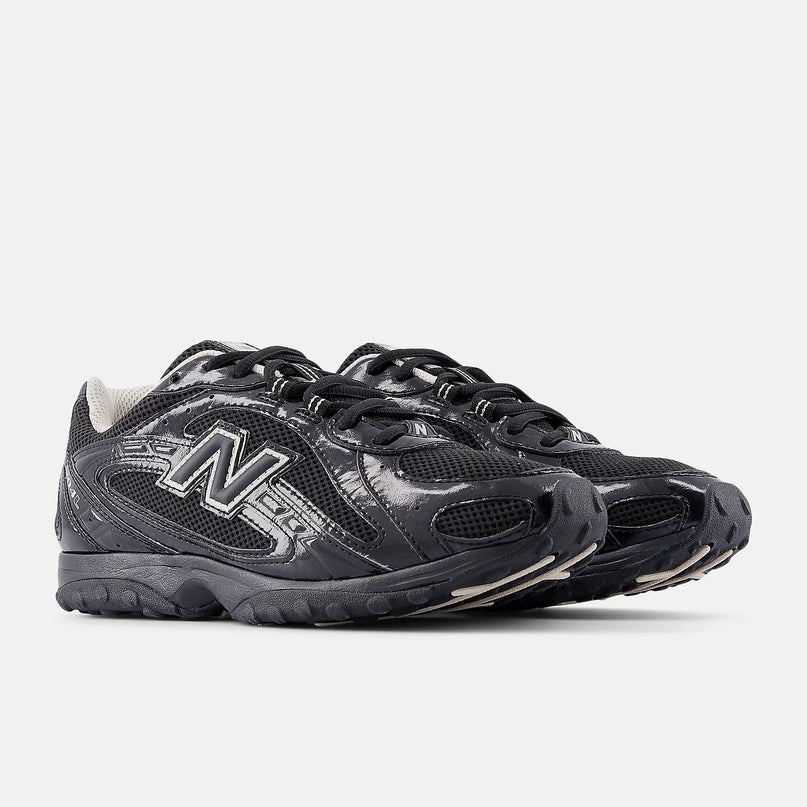 Zwarte New Balance 204L sneakers met Timberwolf details, CAPE EXCLUSIVES, close-up van de sportieve schoen op een witte achtergrond