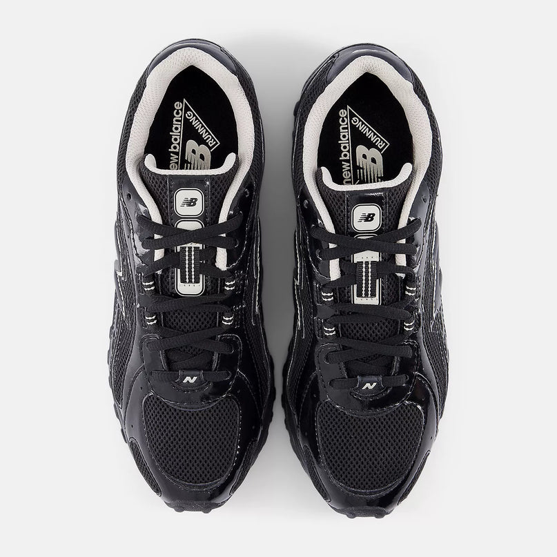 Zwarte New Balance 204L sneakers met Timberwolf details van CAPE EXCLUSIVES, weergegeven op een witte achtergrond.
