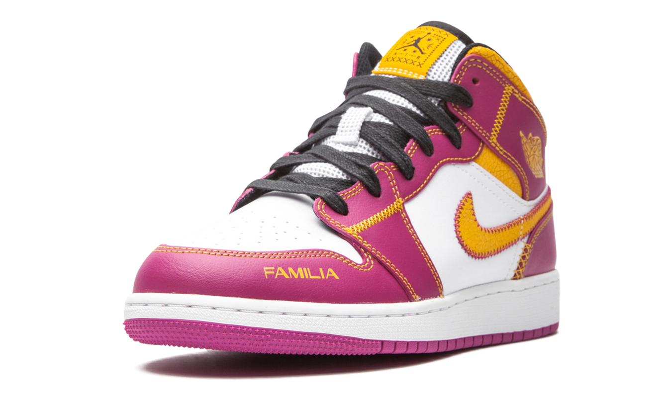 Sneakers Air Jordan 1 Mid DOD GS "Day of the Dead" met kleurrijke details en grafisch ontwerp, gedragen door een model.