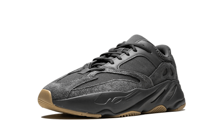 Zwarte Yeezy Boost 700 schoenen met witte zool en gewatteerd bovenwerk, casual sneaker stijl, gefotografeerd van de zijkant.