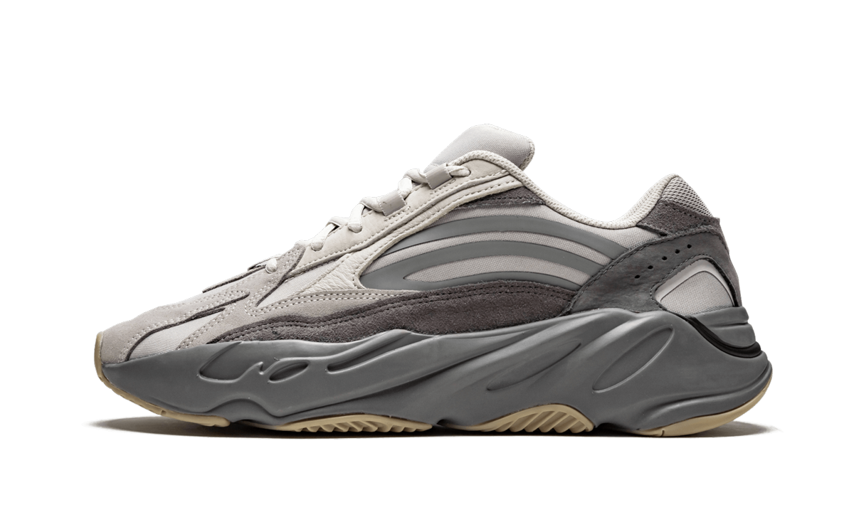 Witte en grijze Yeezy Boost 700 V2 "Tephra" sneakers met dikke zool en stijlvolle design, gedragen door een model.