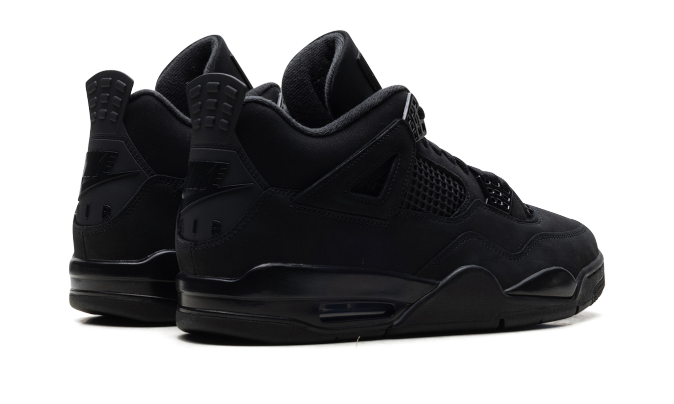 Zwarte Air Jordan 4 schoenen "Black Cat 2025" met leren bovenwerk en witte details, gedragen door een model.