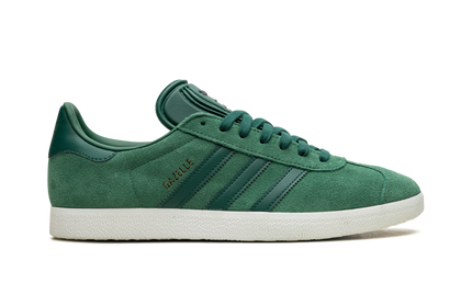 Donkergroene Adidas Gazelle schoenen met witte zool en merklogo, zichtbaar in close-up foto.