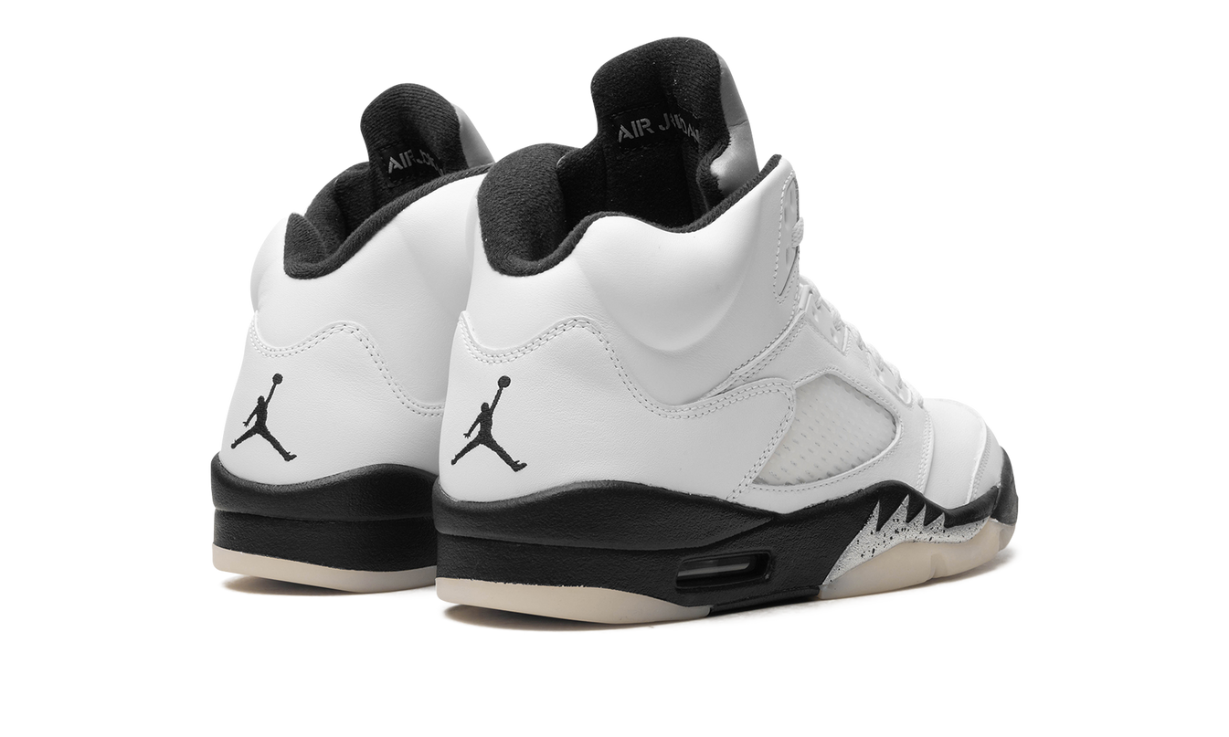 Witte en zwarte Air Jordan 5 sneakers van Mijn winkel, gedetailleerde close-up van de schoenen met witte en zwarte kleuraccenten.