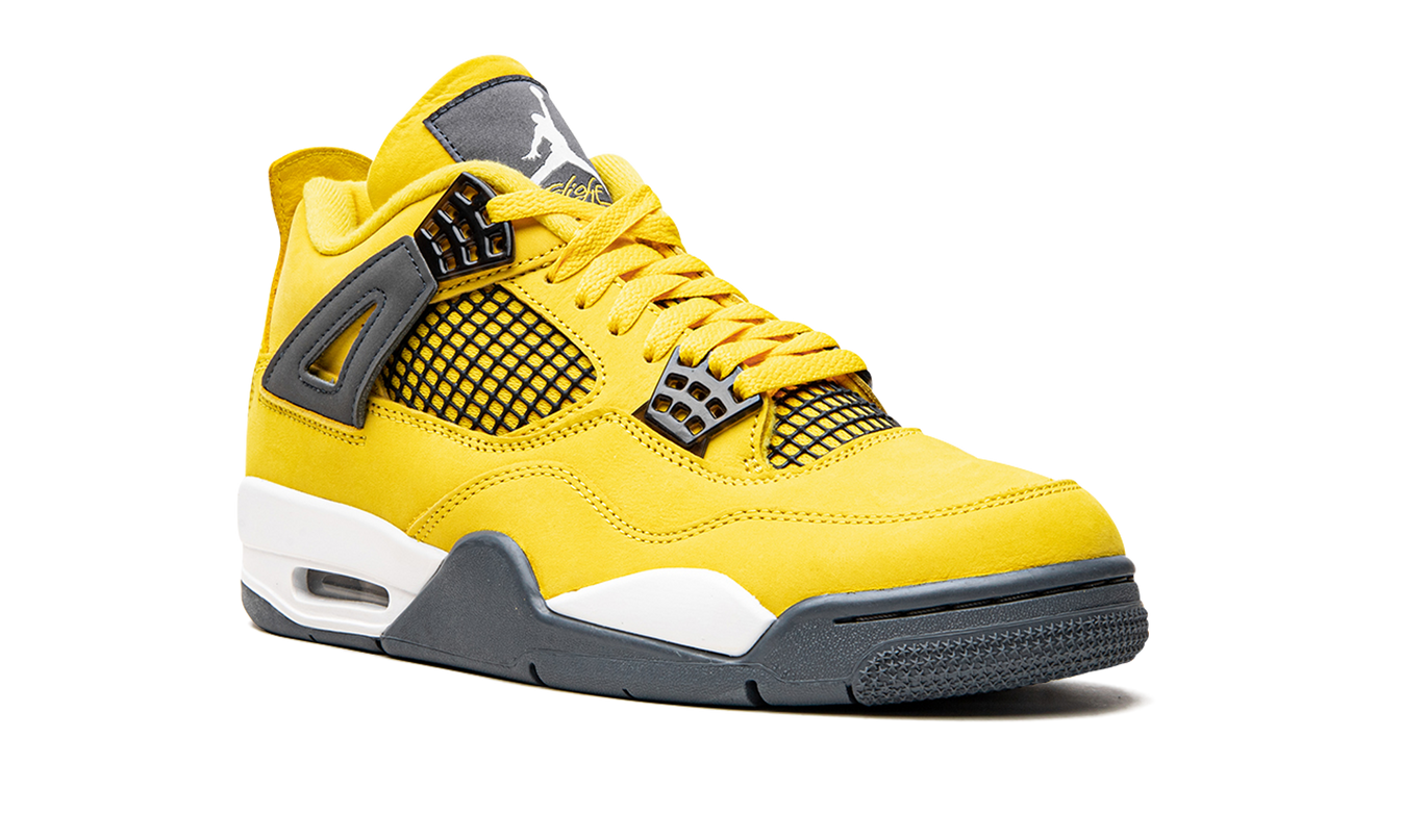 Lichte gele Air Jordan 4 Retro "Lightning 2021" sneakers met witte en zwarte details, zichtbaar in close-up afbeelding.