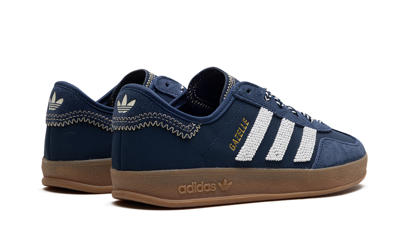 Donkerblauwe Adidas Gazelle schoenen met CLOT-logo, zichtbaar op een paar sneakers in de afbeelding.