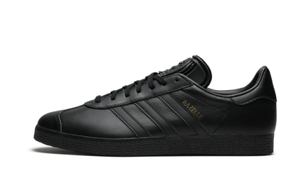 Bruine leren Adidas Gazelle schoenen met witte accenten en zachte zool, zichtbaar van de zijkant op een witte achtergrond
