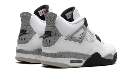 Witte Air Jordan 4 Retro GS sneakers met cementkleurige details en witte leren bovenkant, zichtbaar in de afbeelding.