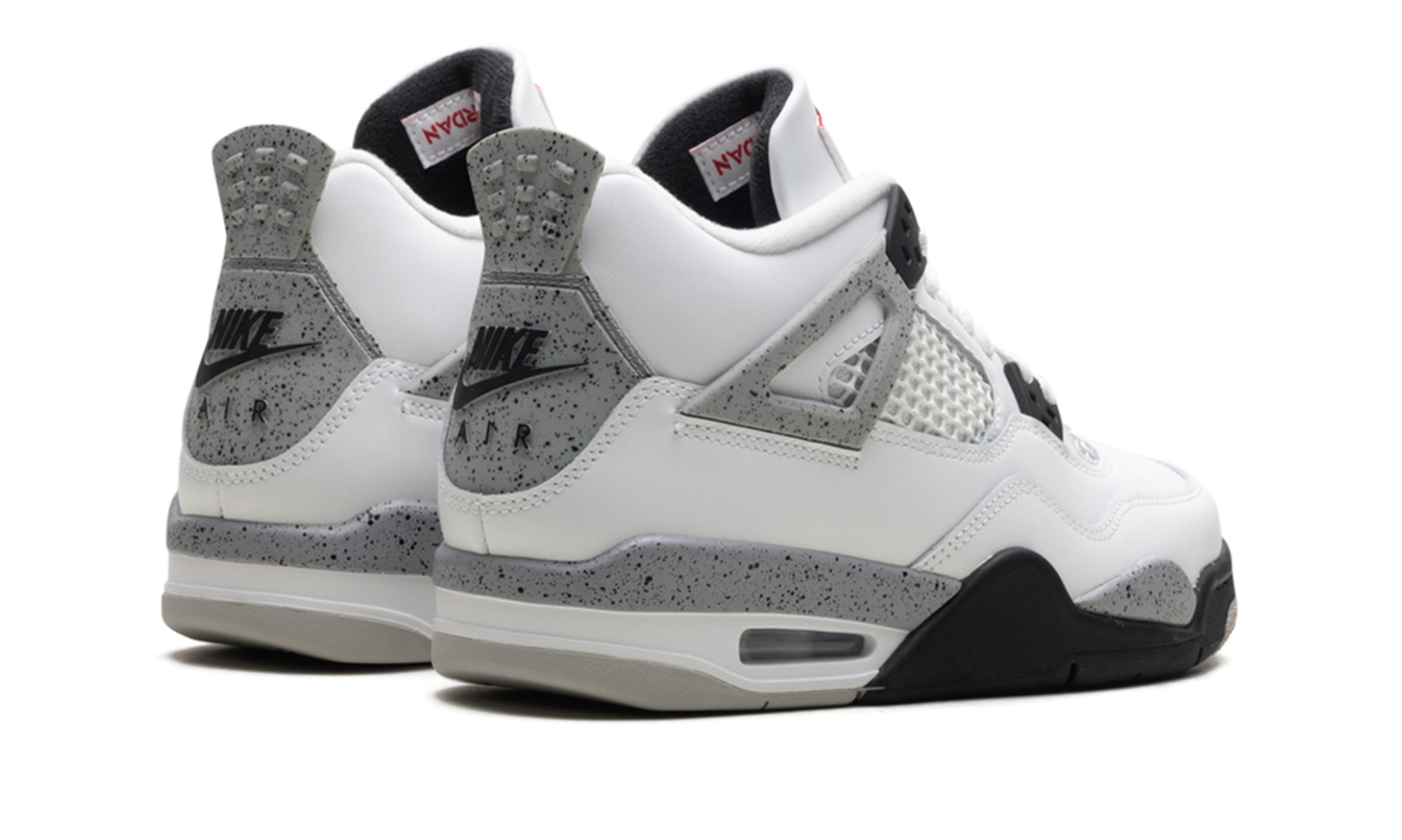 Witte Air Jordan 4 Retro GS sneakers met cementkleurige details en witte leren bovenkant, zichtbaar in de afbeelding.