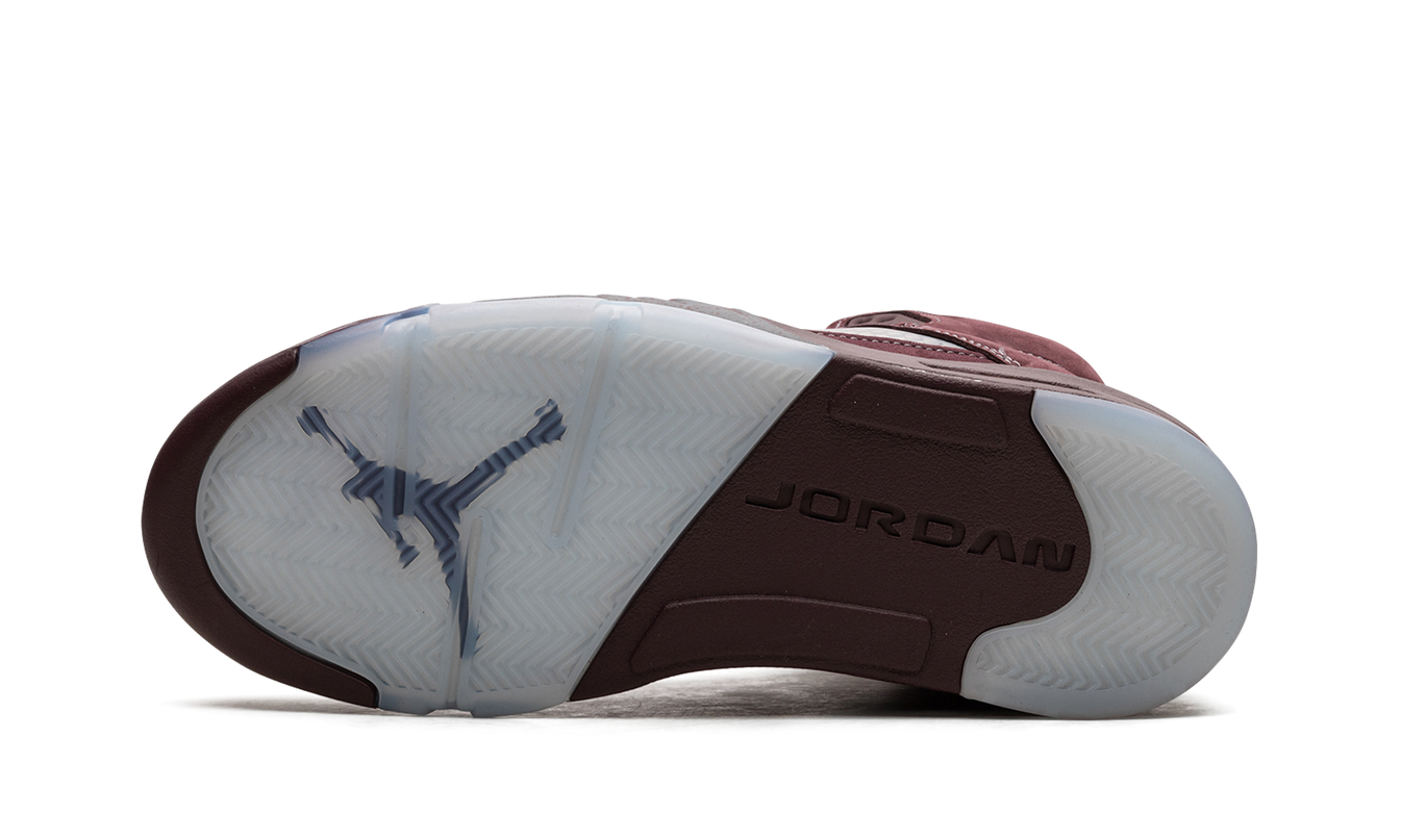 Zwarte en paarse Air Jordan 5 sneakers met burgundy details, zichtbaar op een wit achtergrond.