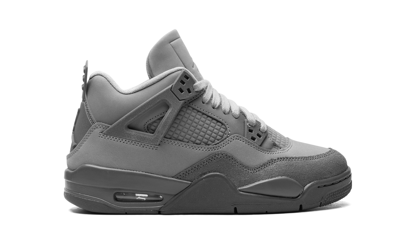 Witte en grijze Air Jordan 4 GS schoenen met "Wet Cement" details, zichtbaar in close-up foto.