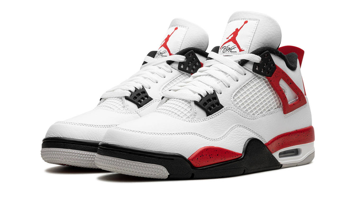 Witte en rode Air Jordan 4 sneakers met cementdetail, lage hoekweergave, Nike Air logo zichtbaar op de zool