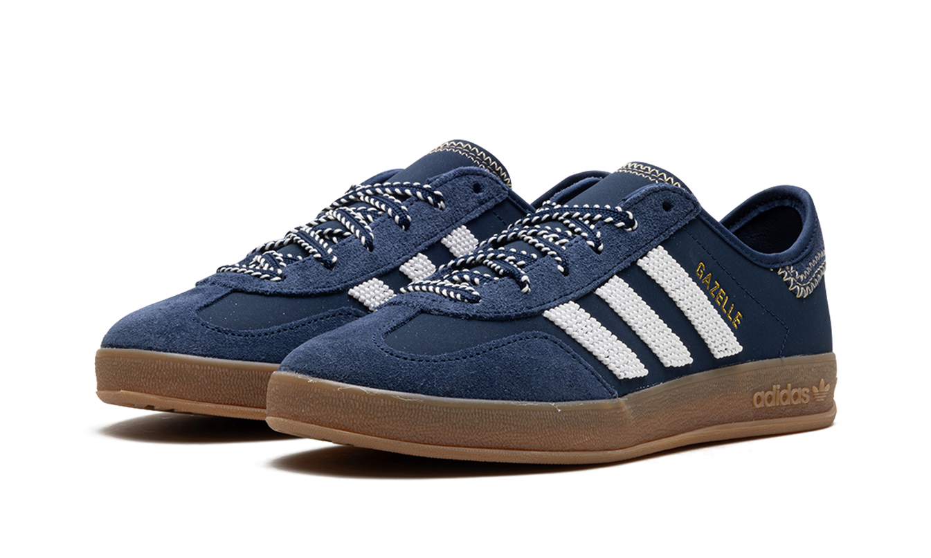 Donkerblauwe Adidas Gazelle schoenen met CLOT-logo, close-up van de stijlvolle sneakers op een witte achtergrond