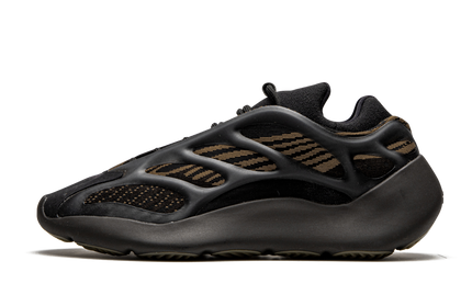 Lichte bruine Yeezy 700 V3 schoenen met zwart en beige details, gedragen door een model op een witte achtergrond.