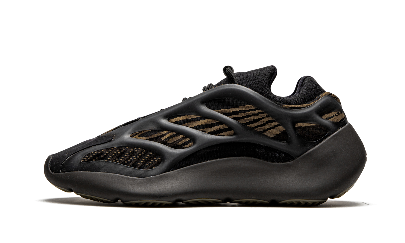 Lichte bruine Yeezy 700 V3 schoenen met zwart en beige details, gedragen door een model op een witte achtergrond.