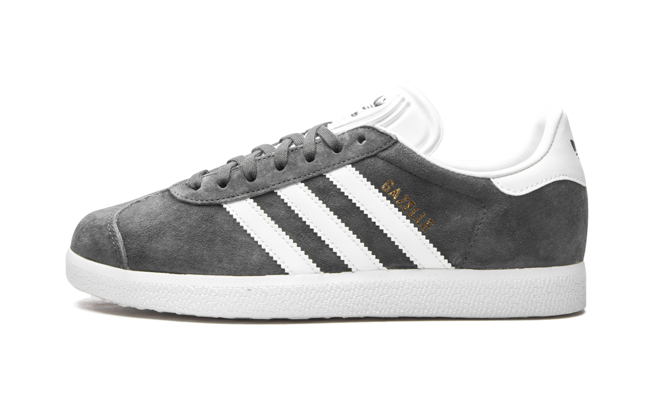 Donkere Adidas Gazelle sneakers in grijs met witte zool, zichtbaar op een witte achtergrond.